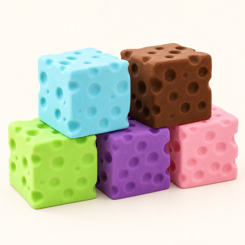 Blue, brown, green, purple and pink SQUEEZU Cheese Cube Squishy toys with molded cheese holes.
