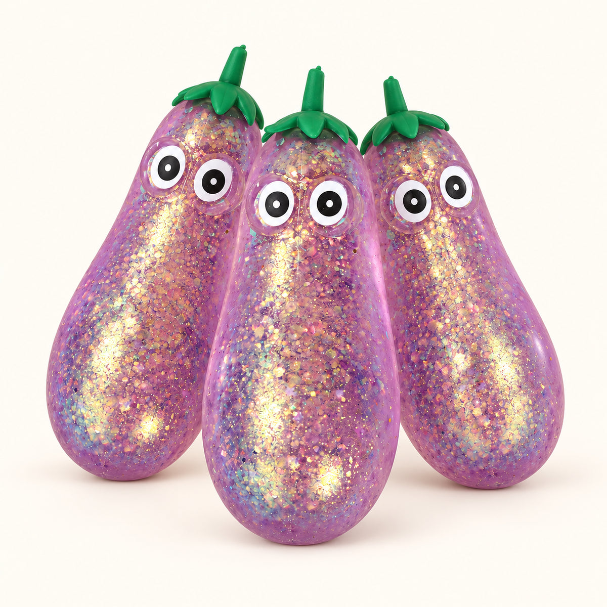 Three purple SQUEEZU Glitter Eggplant Squishy toys with green tops and cartoon eyes.